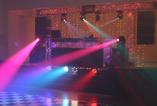 Palco com treliças, iluminação cênica e pista de dança montados para um evento